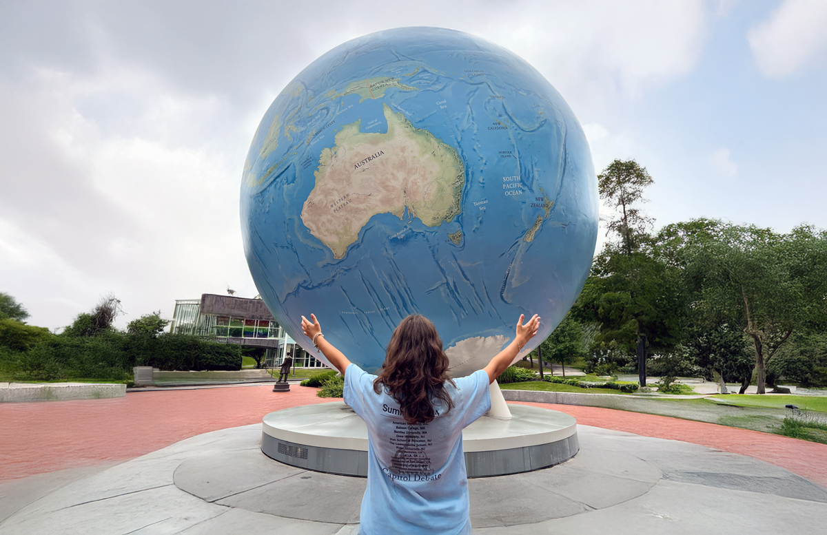 Students sitting beneath world globe at Capitol Debate