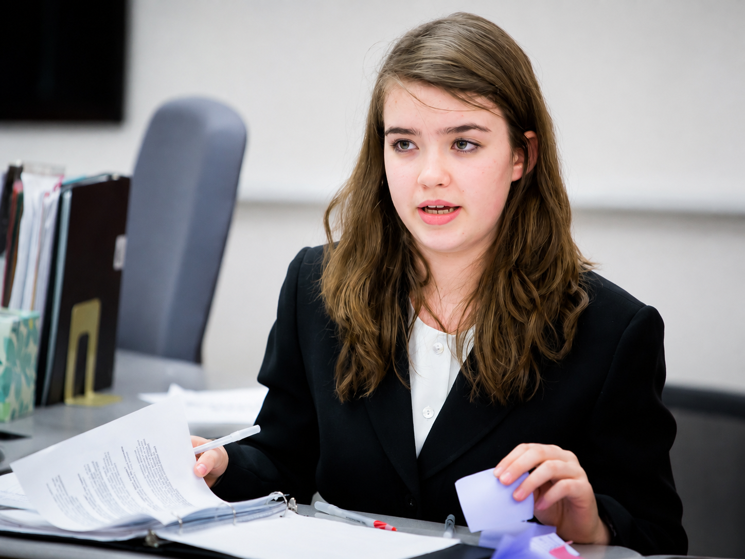 Returning student speaking in formal debate attire